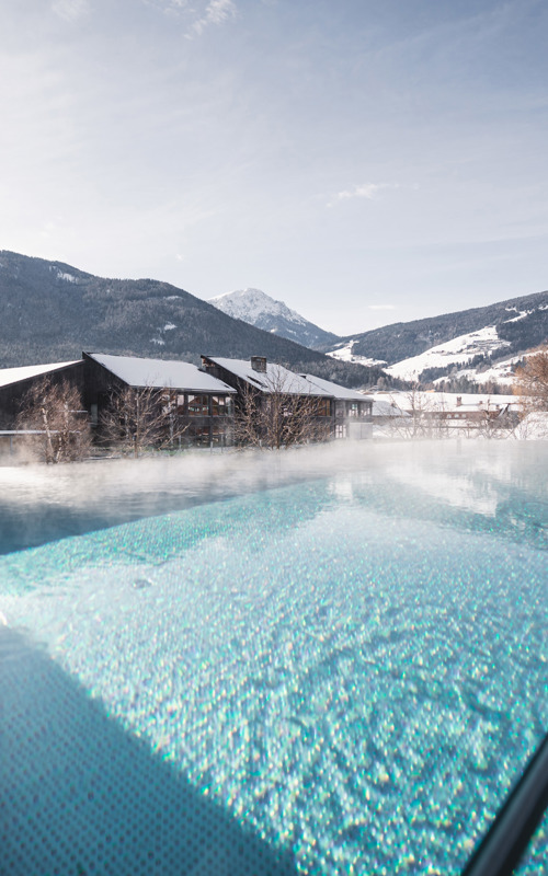 Outdoor hotel pool in winter with mountain view
