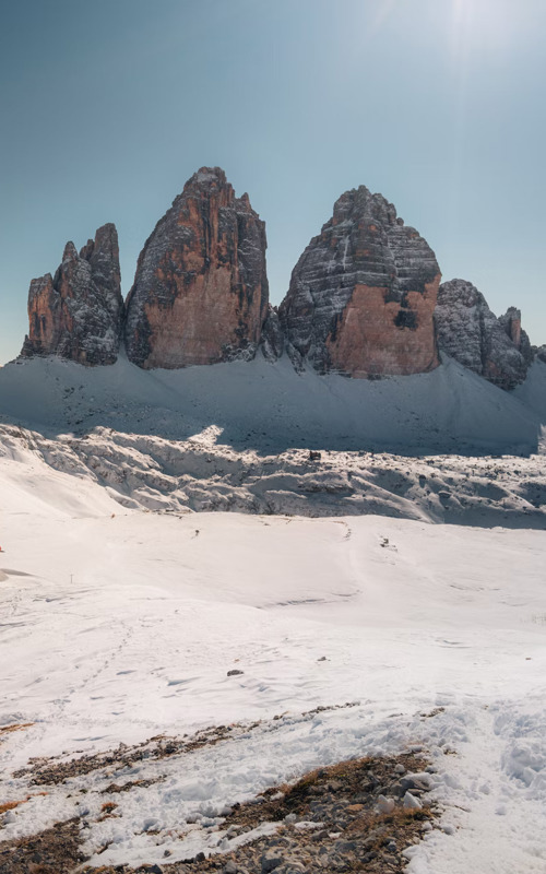 Hut and small church in a snowy landscape surrounded by Dolomites peaks