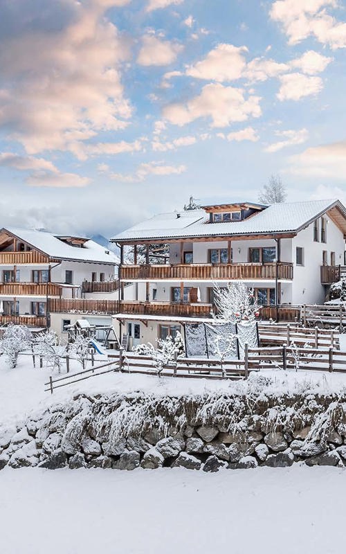 Snow-covered house framed with fences in the snow